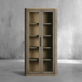 Wooden cabinet with glass doors against a gray concrete wall.