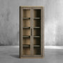 Wooden cabinet with glass doors against a gray concrete wall.