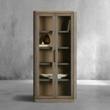 Wooden cabinet with glass doors against a gray concrete wall.