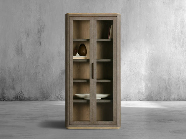 Wooden cabinet with glass doors against a gray concrete wall.