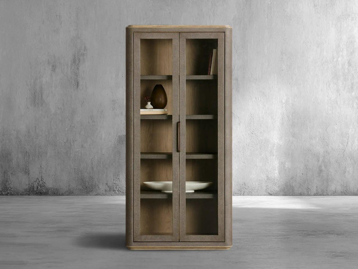 Wooden cabinet with glass doors against a gray concrete wall.
